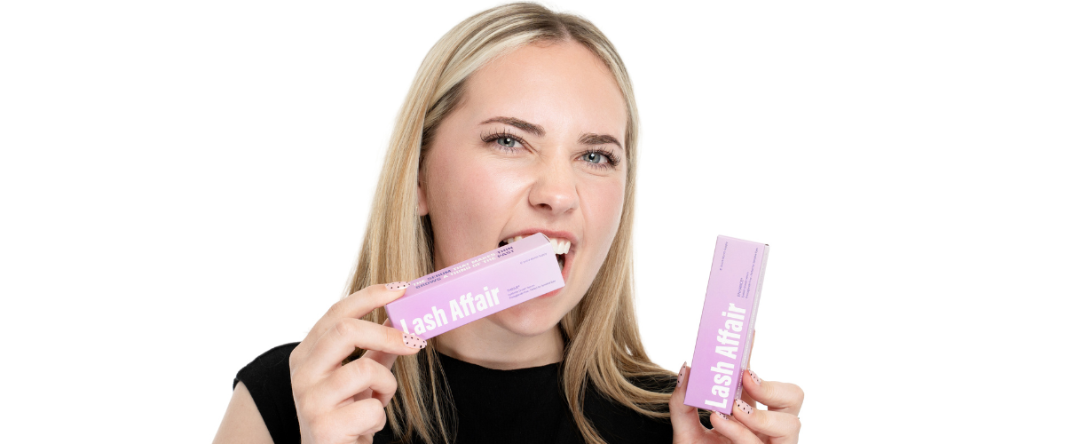 Woman holding one eyelash growth serum and one eyebrow growth serum