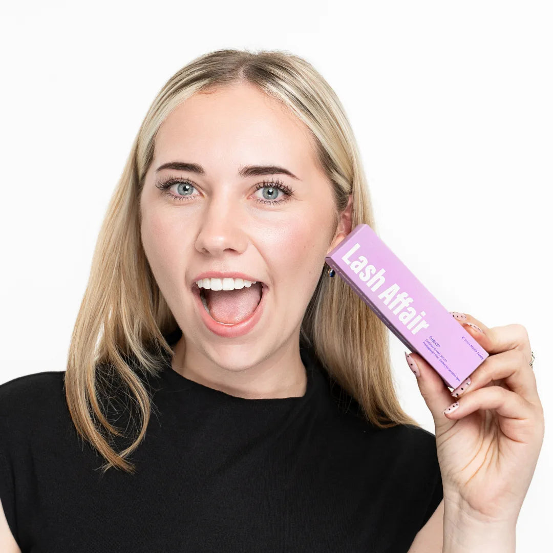 woman holding an eyebrow serum in front of her face