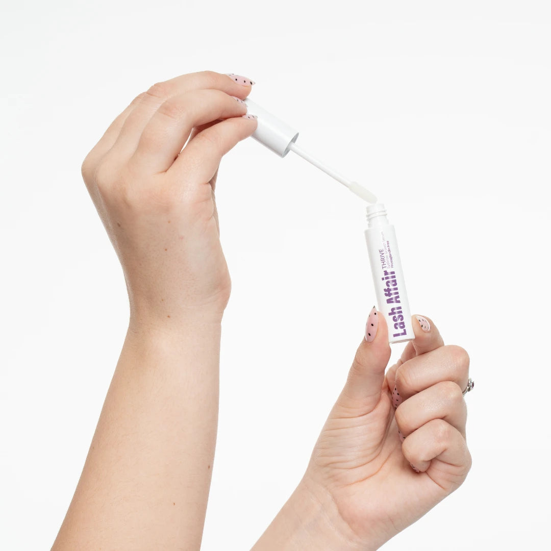 hand holding a brow serum with white background